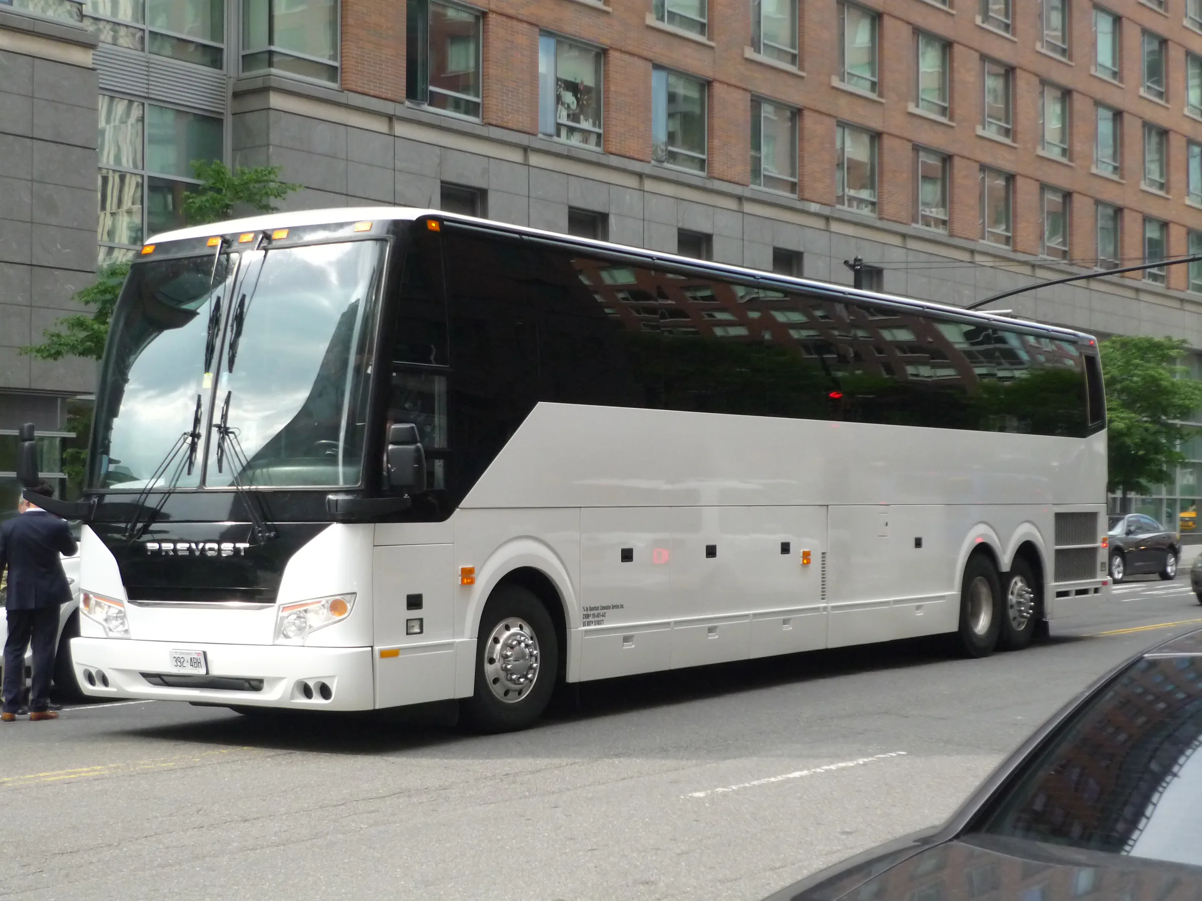 White Prevost H3-45 full-size motorcoach on a city street